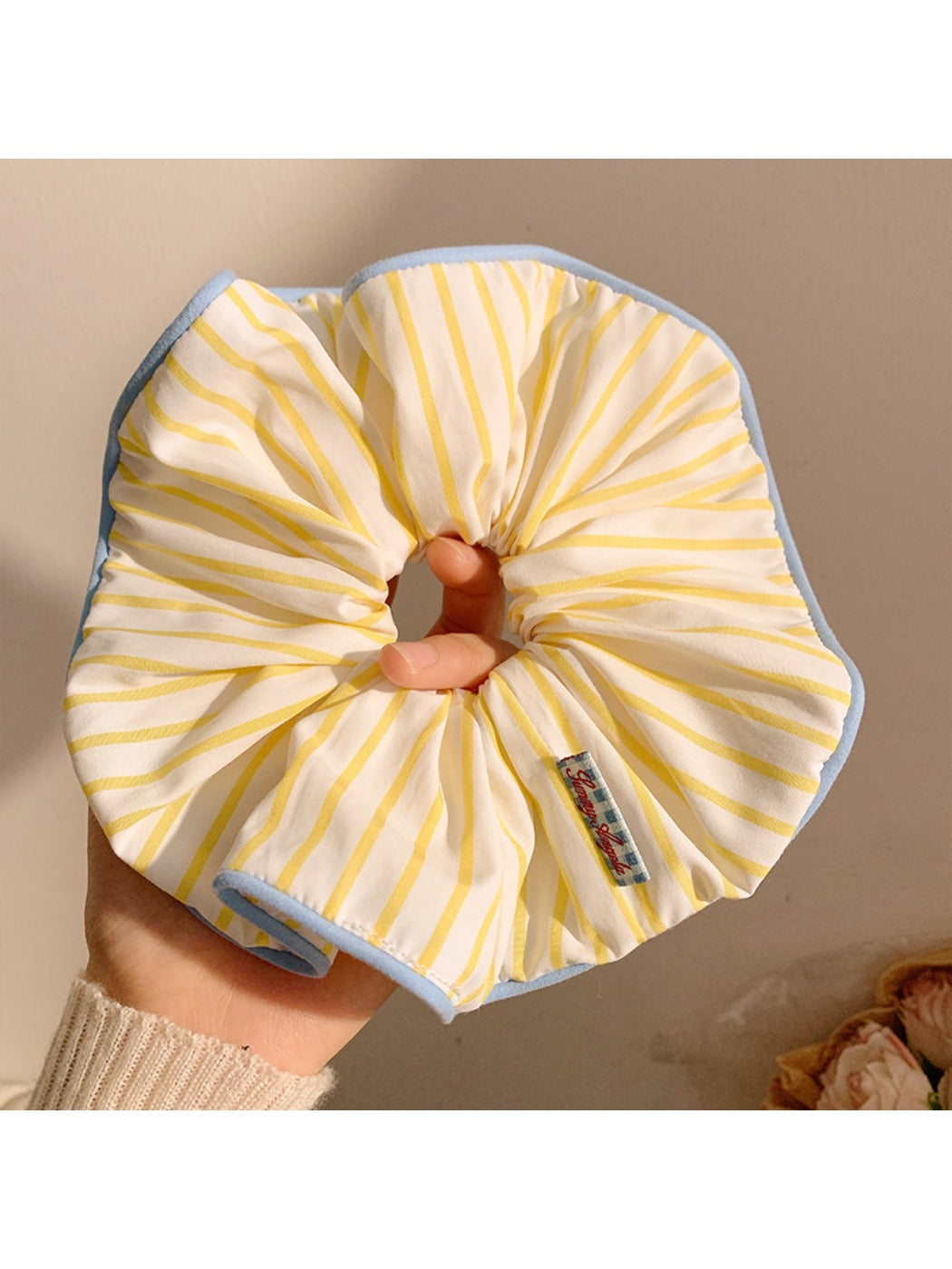 Yellow striped scrunchie styled with casual outfit on a model