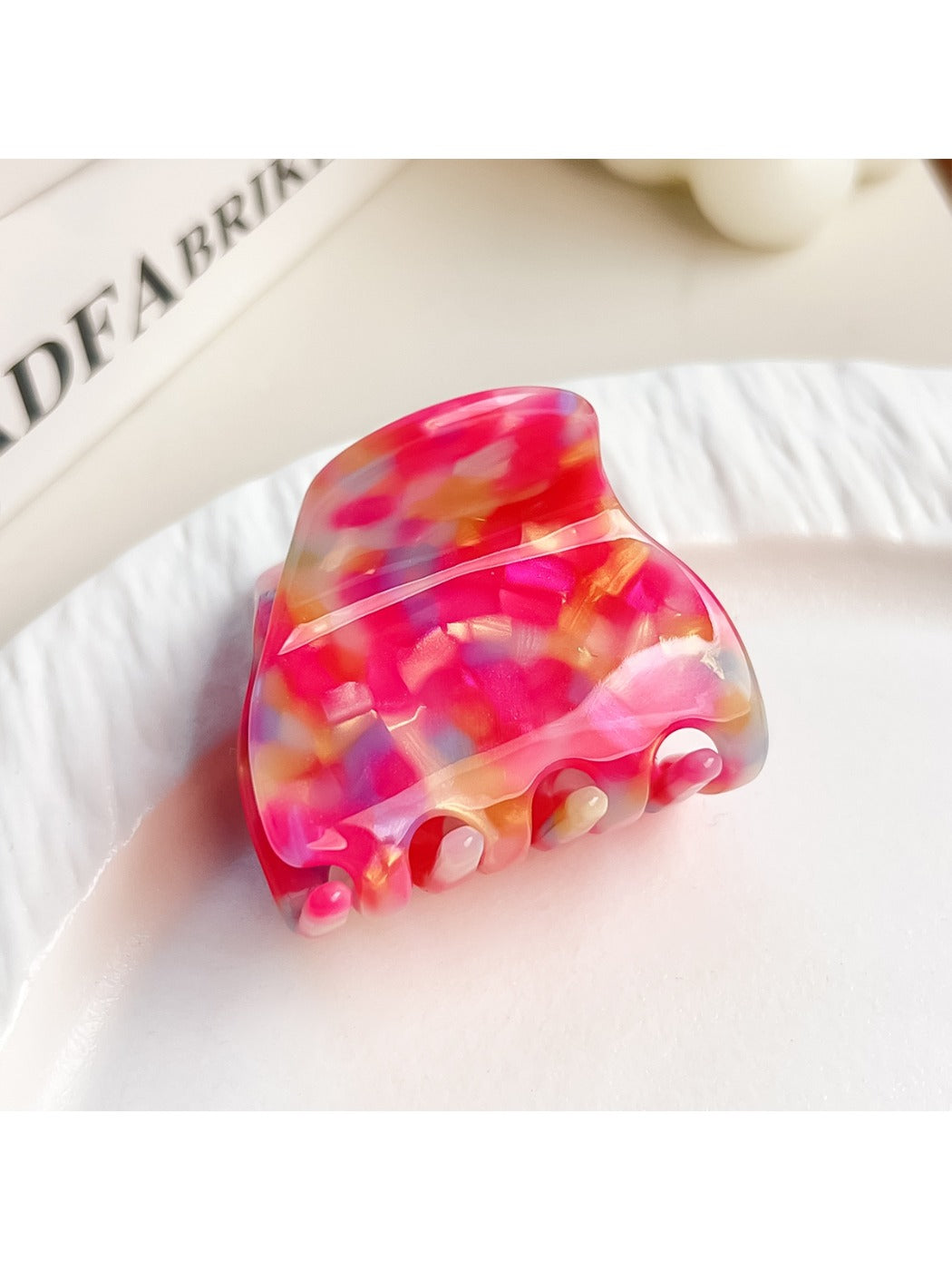 Beau multicolored half moon claw clip displayed with soft lighting