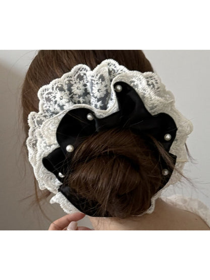 Close-up of beige lace trim detail on satin scrunchie