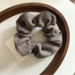 Gifty scrunchie in natural light emphasizing neutral color stripes