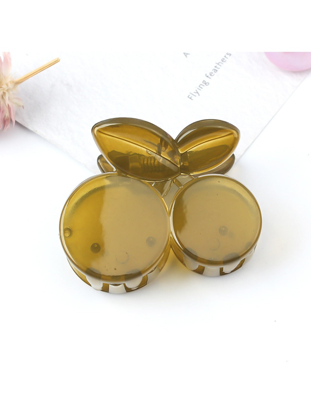 Beau cherry claw clip placed on a wooden surface with natural light