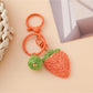 Top view of the strawberry charm keychain highlighting the green leaf details