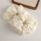 Gifty scrunchie wrapped around a ponytail on dark hair