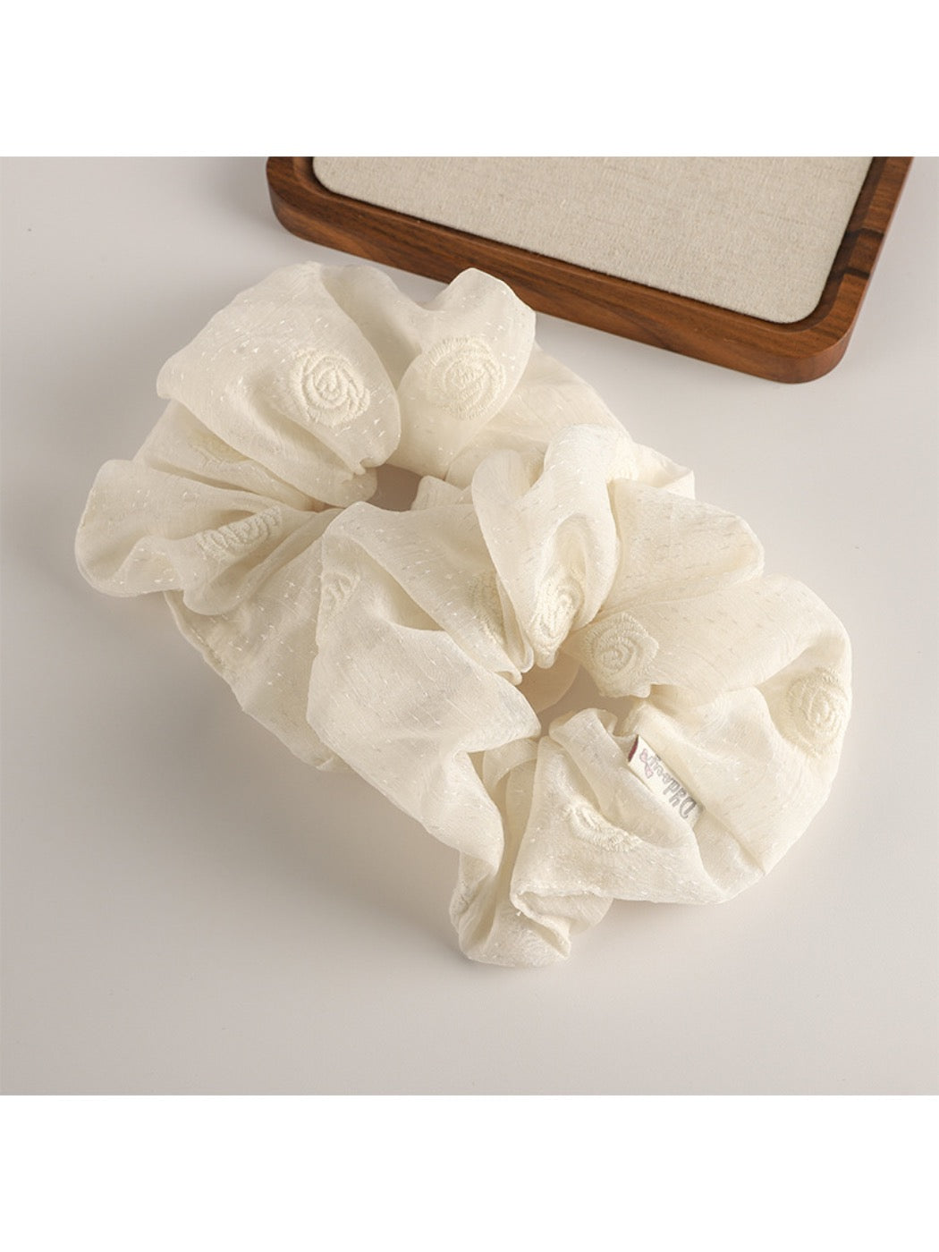Gifty scrunchie wrapped around a ponytail on dark hair