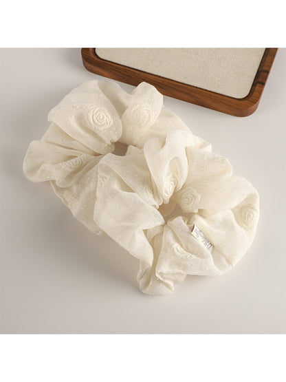 Gifty scrunchie wrapped around a ponytail on dark hair