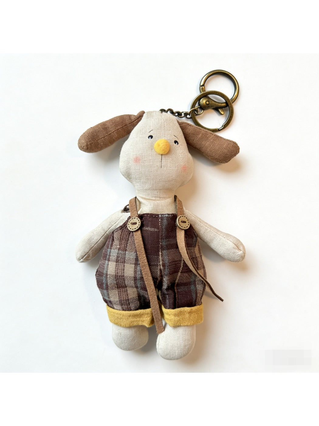 Puppy keychain hanging from a set of keys on a wooden surface