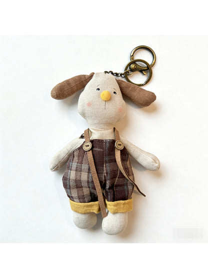 Puppy keychain hanging from a set of keys on a wooden surface
