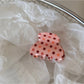 Beau pink polka dot hair clip photographed with soft natural lighting