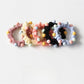 Set of sweet pastel-colored beaded hair ties displayed on a wooden surface