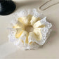Close-up of yellow and white color block hair scrunchie on white background