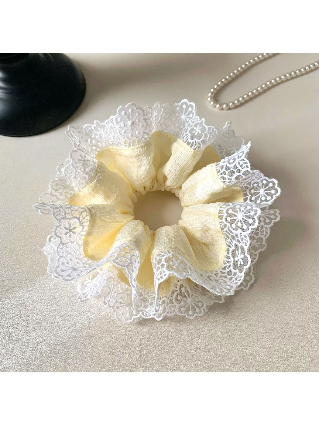 Close-up of yellow and white color block hair scrunchie on white background