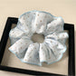 Multiple Gifty polka dot scrunchies in different colors arranged in a circle