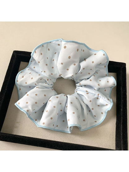 Multiple Gifty polka dot scrunchies in different colors arranged in a circle