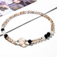 Lovra bracelet wrapped multiple times around a wrist, highlighting black and gold crystals