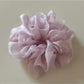Gifty scrunchie in a loose bun hairstyle with natural lighting