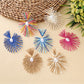 Close-up of Earedge elegant raffia drop earrings on white background
