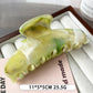 Beau plastic updo claw clip in beige on a reflective surface with soft lighting