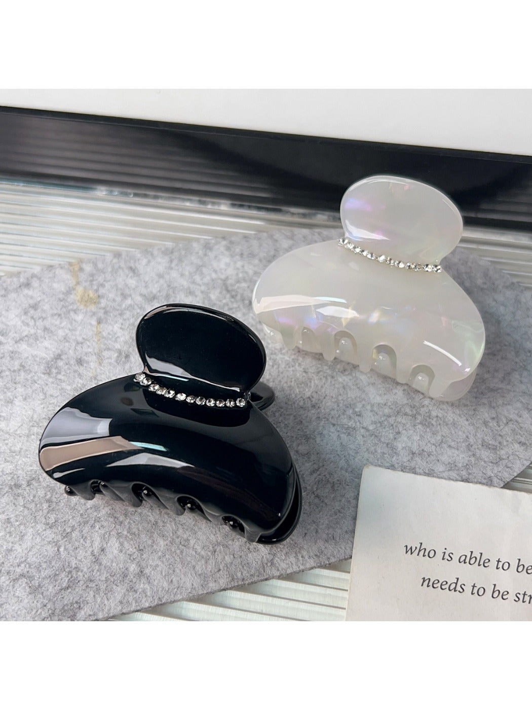 Beau half round hair claw clip showing curved teeth and spring mechanism