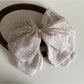 Beau chiffon bow shaped claw clip worn in model's hair from side angle