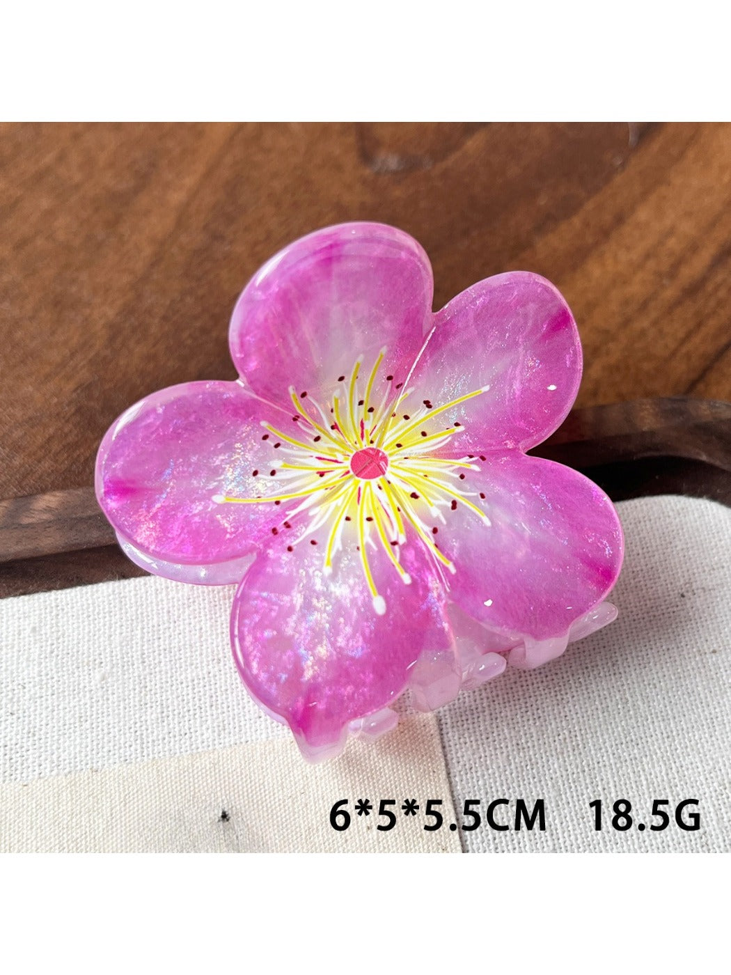 Beau claw clip placed on white surface showing full flower design and glossy finish