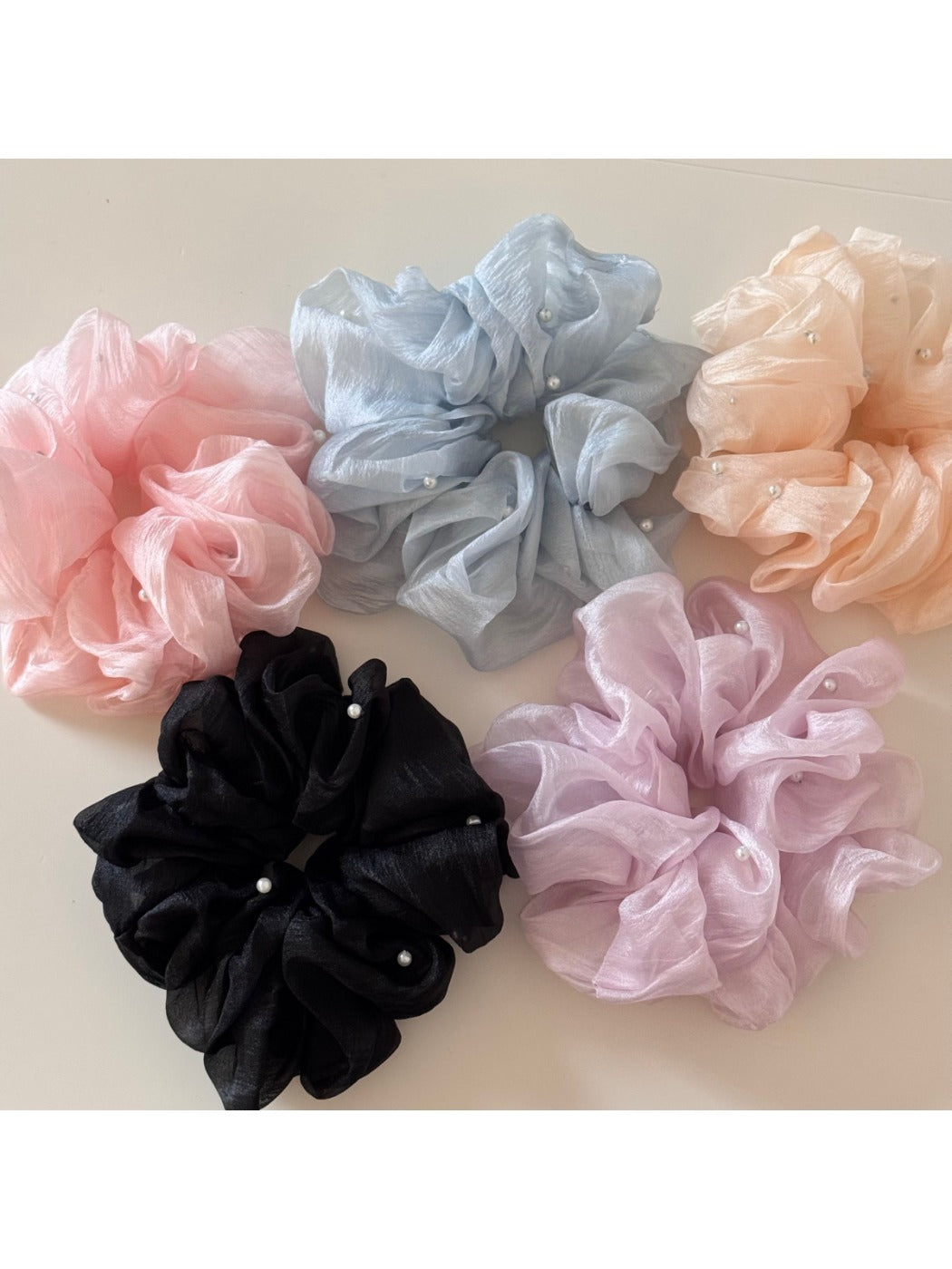 Multiple Gifty scrunchies displayed on a white surface highlighting fabric details