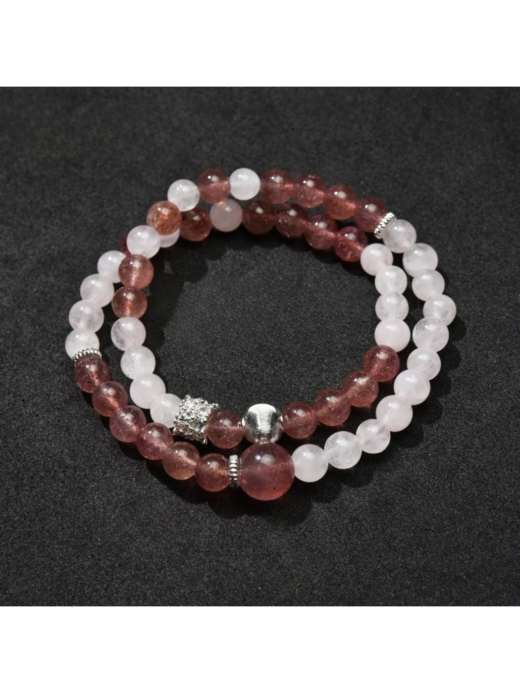 Lovra bracelet coiled on a wooden surface showcasing natural bead colors