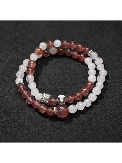 Lovra bracelet coiled on a wooden surface showcasing natural bead colors