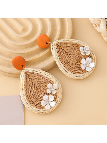Earedge raffia teardrop earrings displayed with green leaves in the background