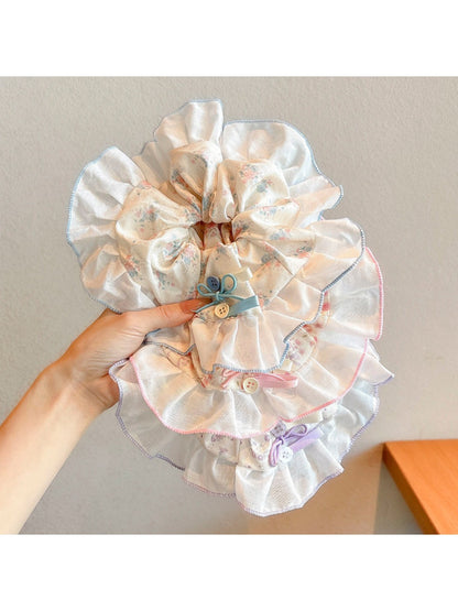 Close-up of Gifty sweet tiny floral high stretch scrunchie with pastel flowers on fabric