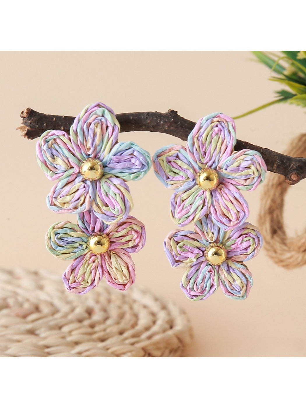 Earedge raffia drop earrings hanging on a wooden stand