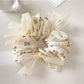 Close-up of Gifty tiny floral print bow scrunchie on white background