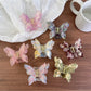 Beau butterfly shaped claw clip in pastel pink on white background