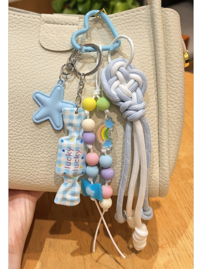 Blue candy star keychain displayed next to a smartphone and notebook