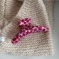 Beau pink leopard print hair clip with light reflecting off acetate material