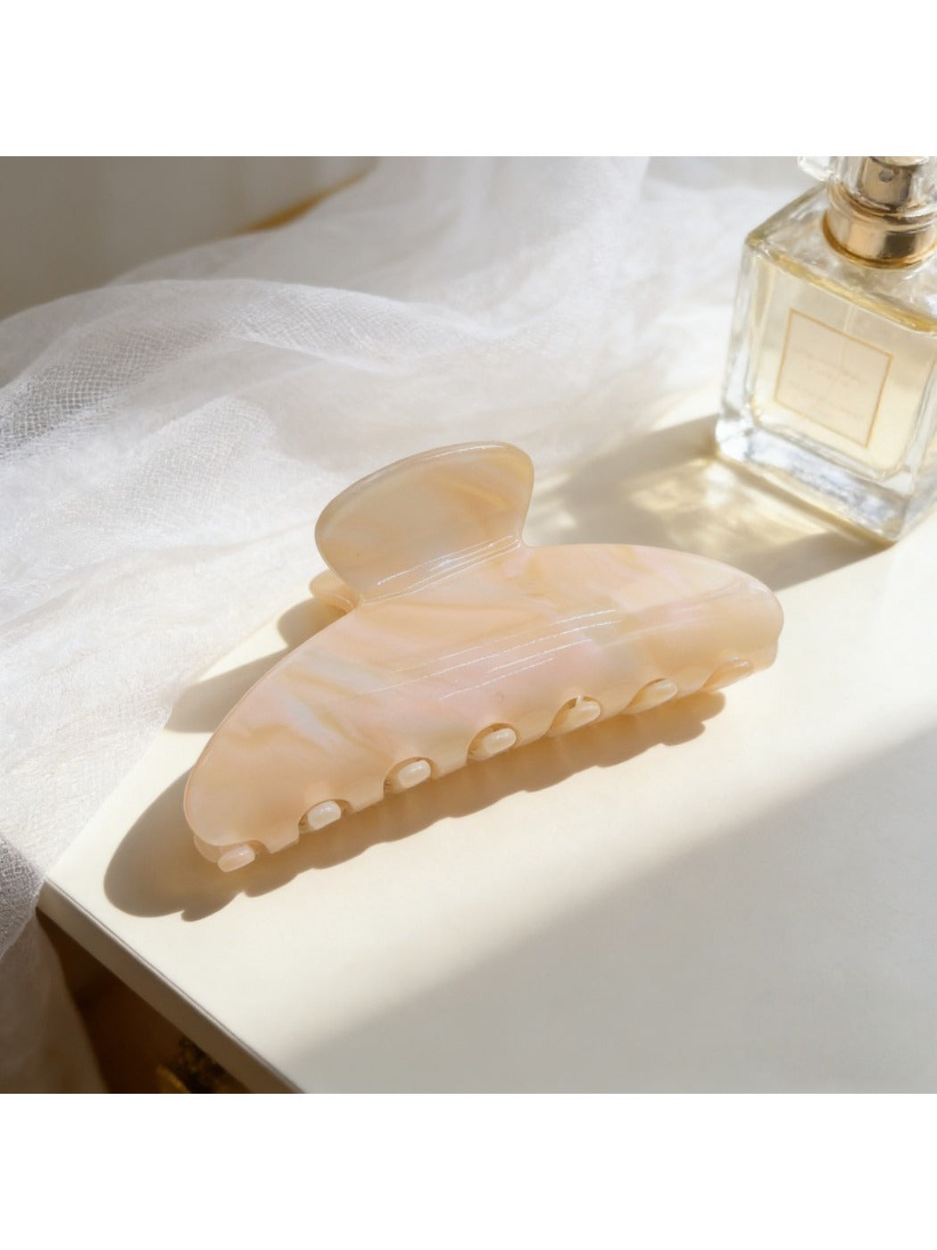 Beau high ponytail claw clip placed next to matching hair accessories on a wooden surface