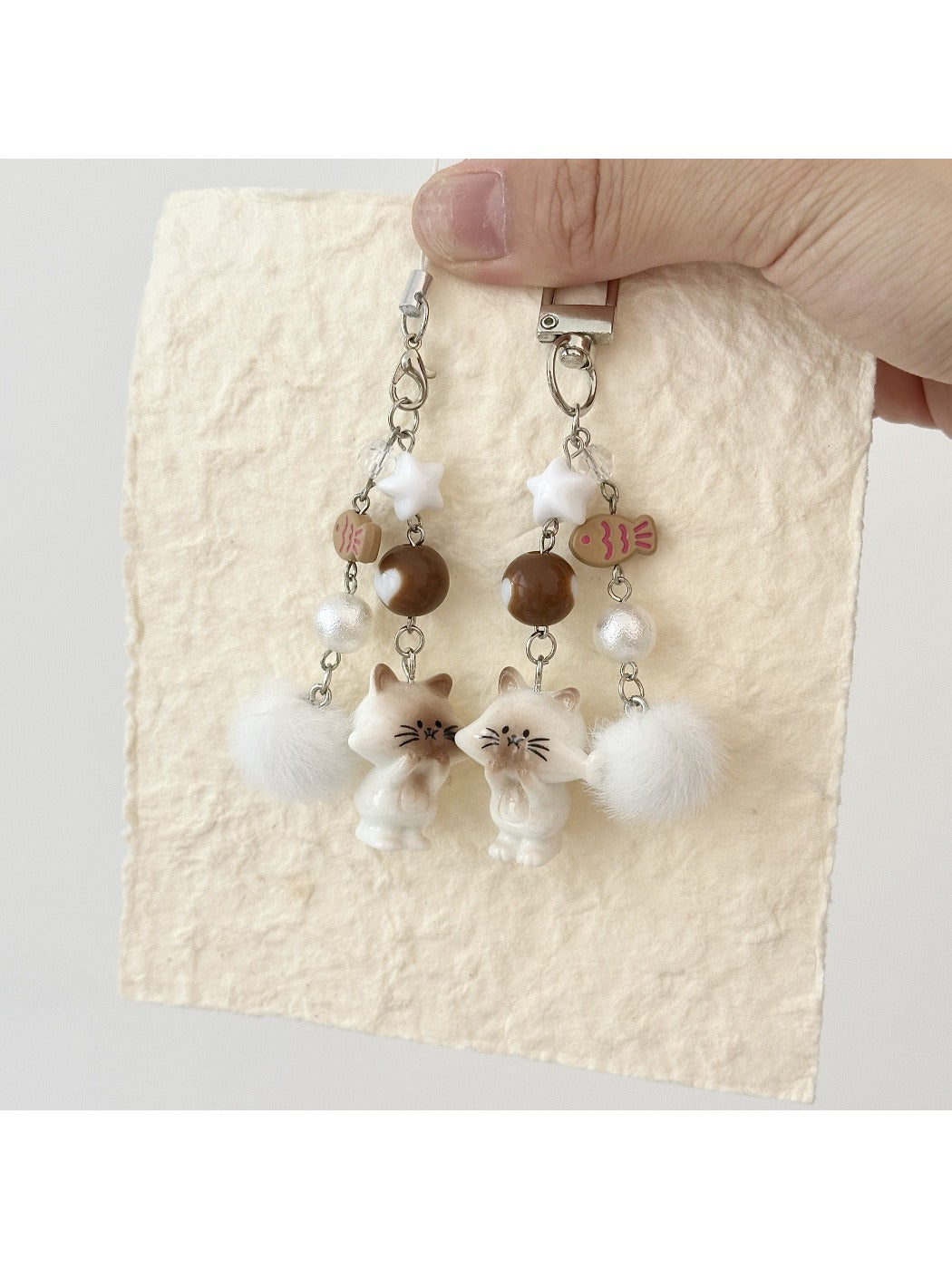 Fish keychain hanging from a silver keyring against a wooden surface