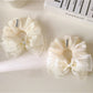 Large pink tulle bow scrunchie on a white background