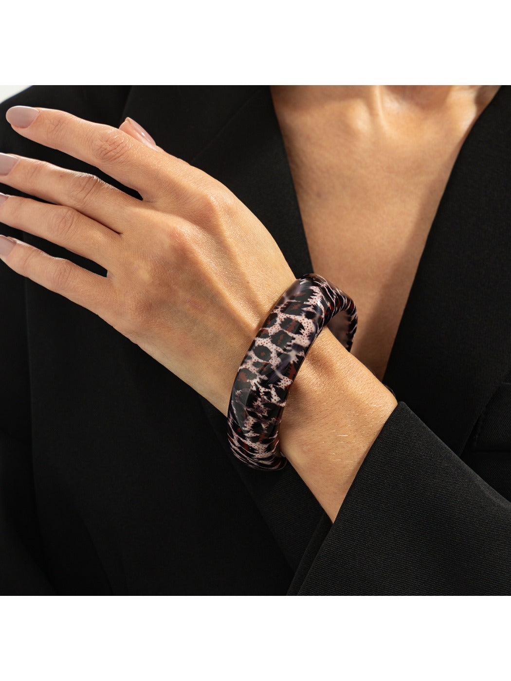 Lovra leopard print bangle bracelet shown with a soft shadow on a neutral background