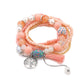 Lovra bracelet with tassel pendant and beads arranged in a circular pattern on a flat surface