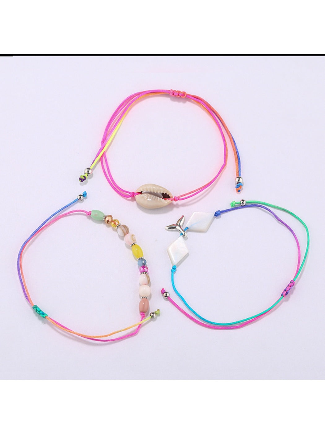 Close-up of Lovra mermaid tail charm and small beads on alloy bracelet