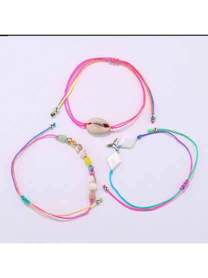 Close-up of Lovra mermaid tail charm and small beads on alloy bracelet
