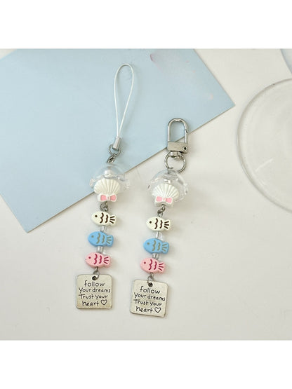 Close-up of a single pastel blue fish-shaped keychain with textured details
