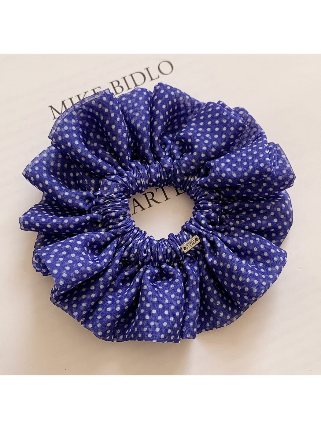 Classic polka dot ruffled scrunchie in black and white fabric close-up