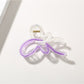 Butterfly hair clip with soft pastel hues on a light fabric background