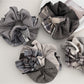 Gifty scrunchie styled on a wrist showing smooth, polished fabric texture