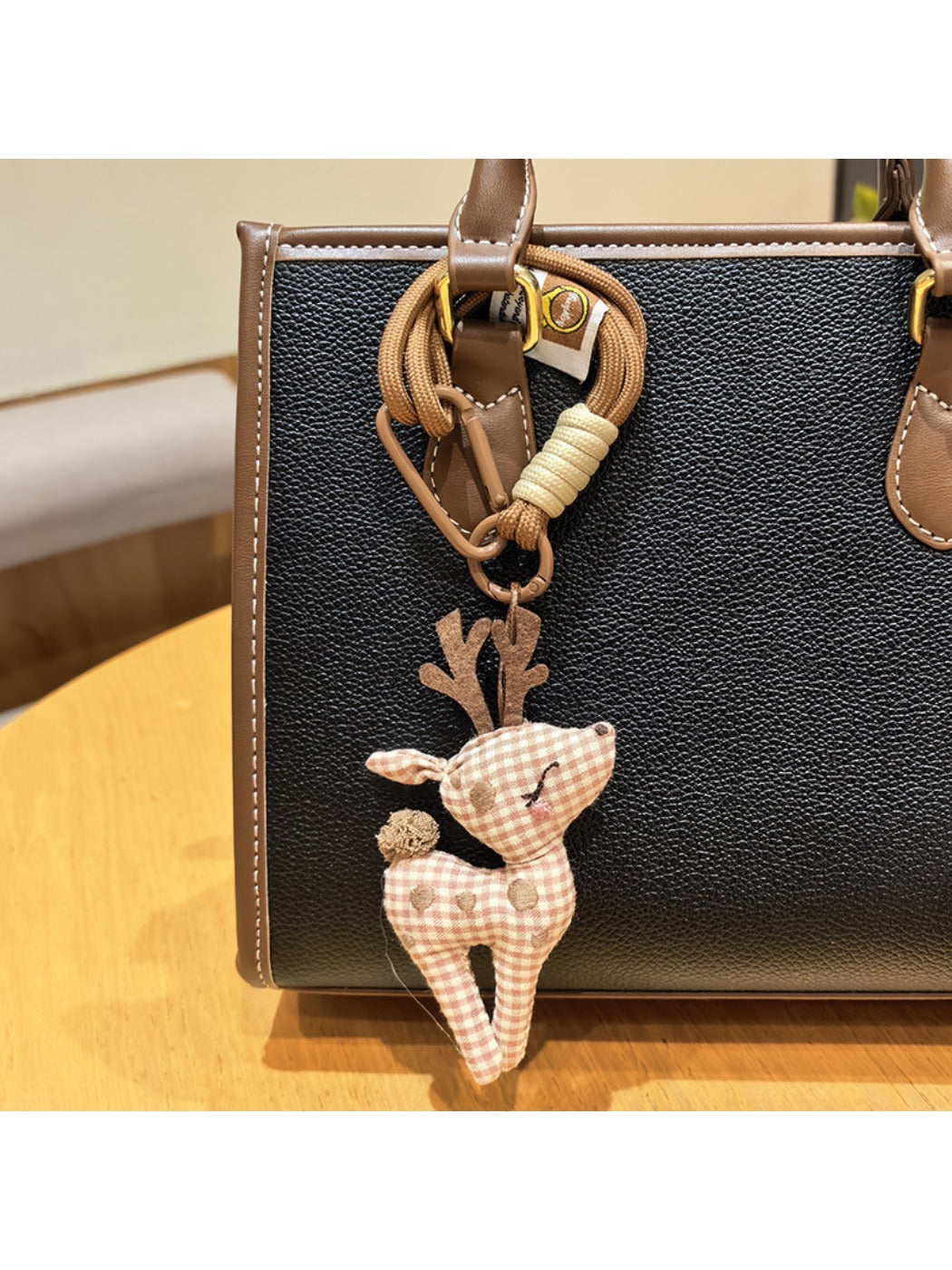 Stylish deer charm keychain displayed with other metallic accessories