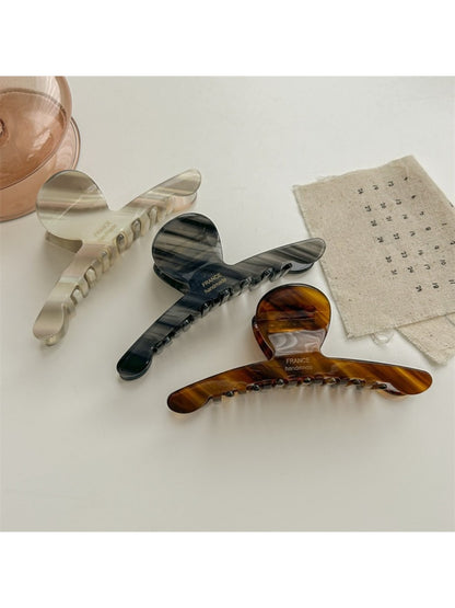 Beau chic acetate claw clip holding a section of brown hair