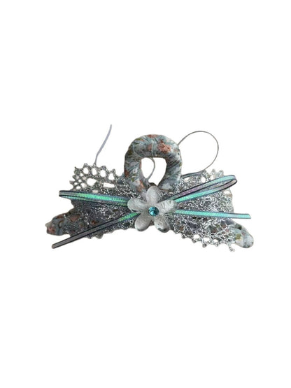 Close-up of Beau floral bow hair clip showing detailed fabric flowers and clip mechanism