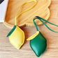 Close-up of a cute lemon-shaped keychain with a silver keyring on a white background