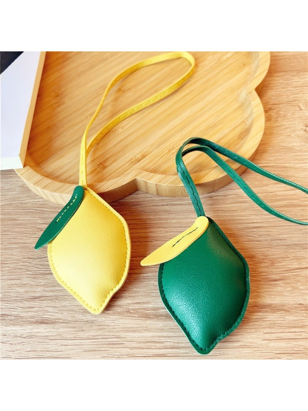 Close-up of a cute lemon-shaped keychain with a silver keyring on a white background